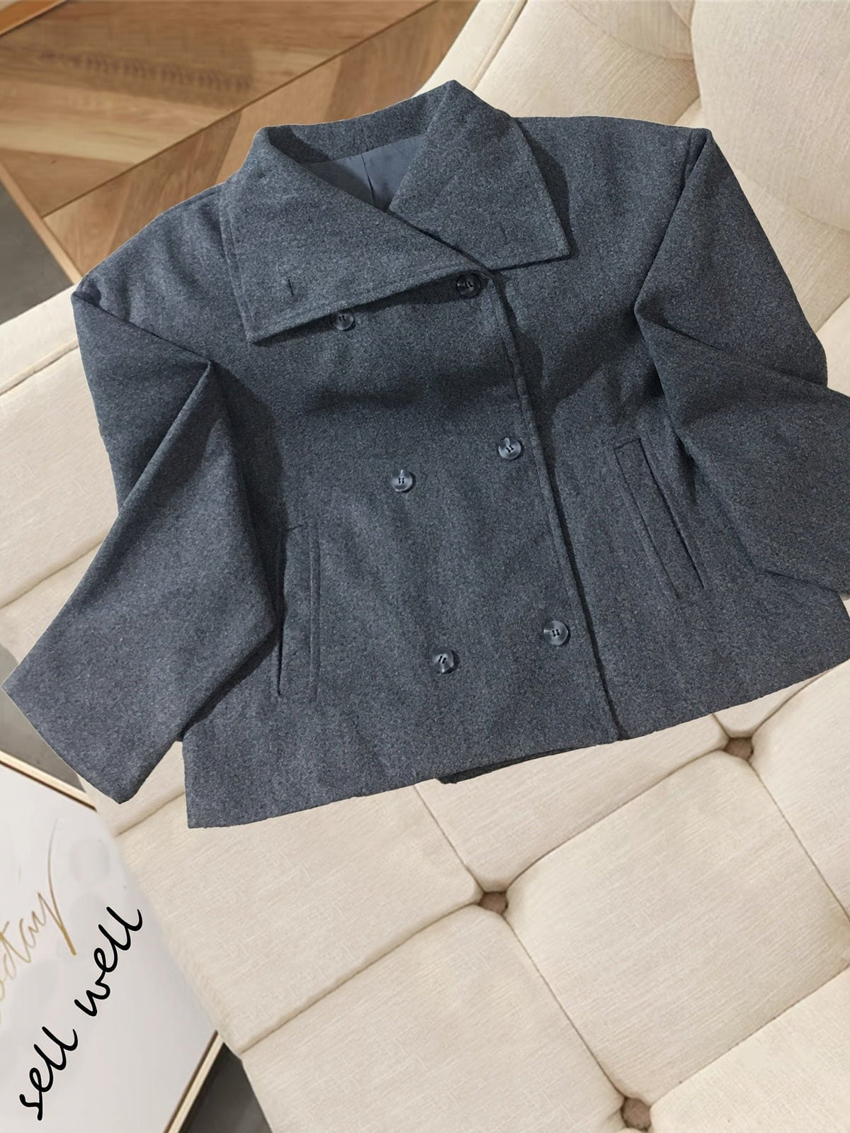 Woman wearing a double breasted cropped blazer with notch lapel and long sleeves in a tailored silhouette._1
