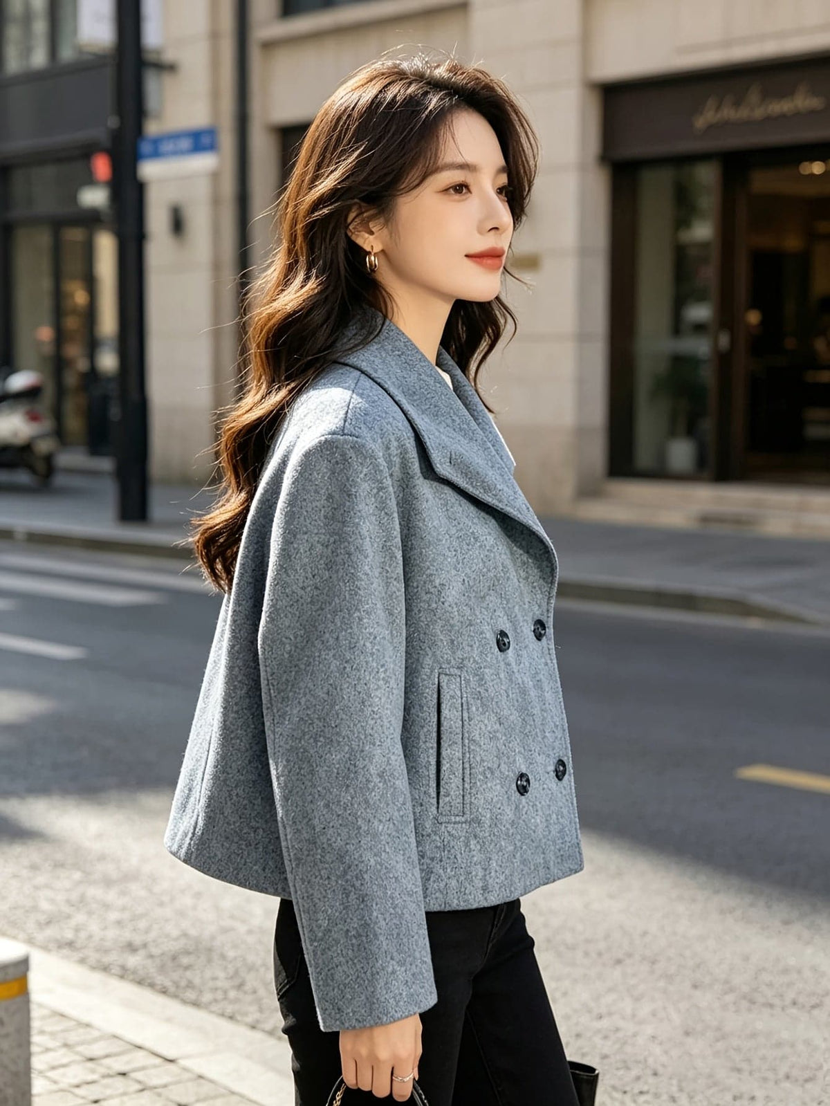 Woman wearing a double breasted cropped blazer with notch lapel and long sleeves in a tailored silhouette._7