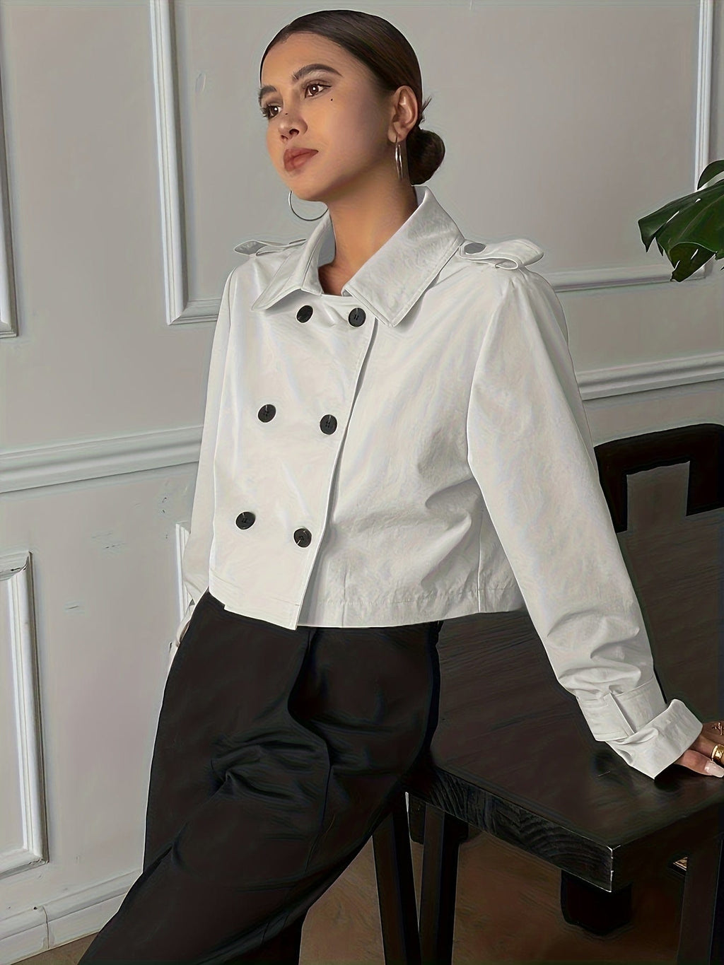 Woman wearing a cropped double-breasted jacket with notch lapel, epaulette shoulder tabs, and buckle cuff sleeves, paired with a white top and dark trousers._1
