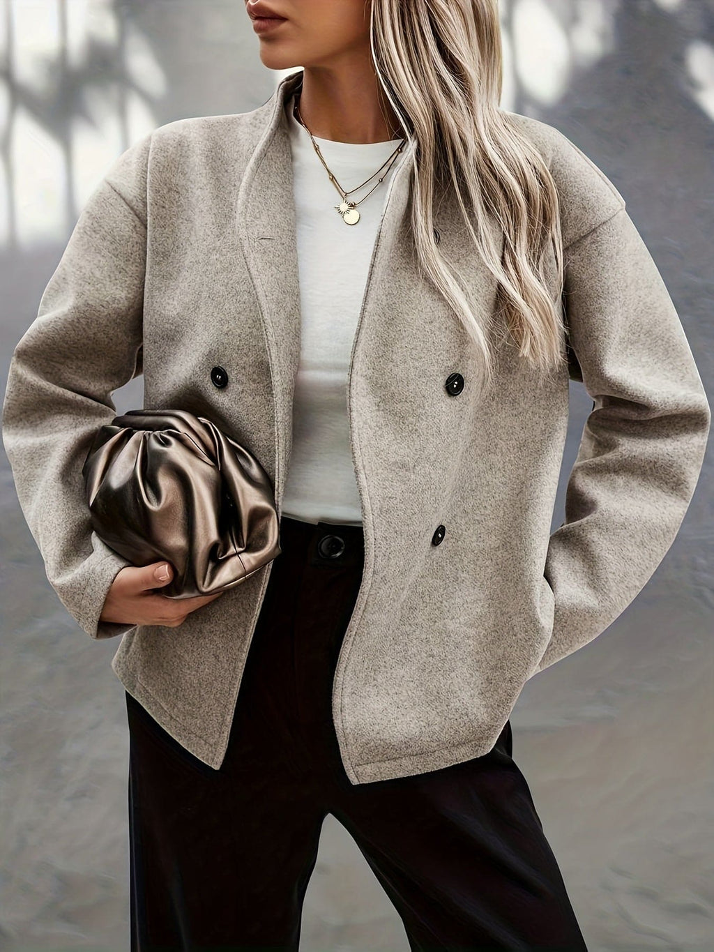 Woman wearing a beige double breasted pea coat with stand collar and oversized silhouette on a city street._2