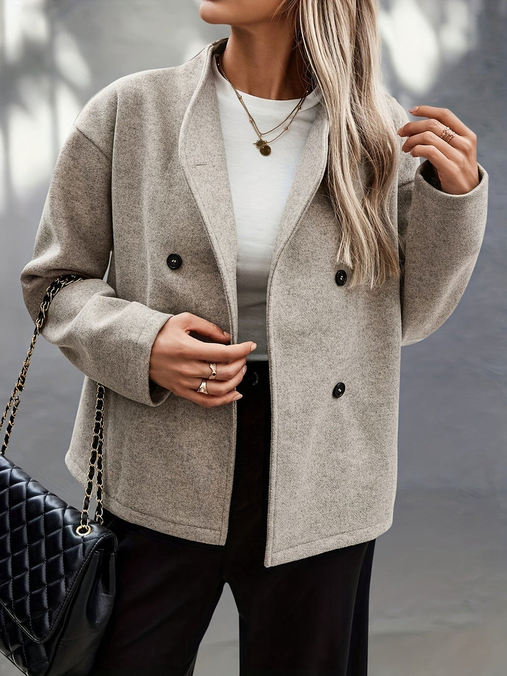 Woman wearing a beige double breasted pea coat with stand collar and oversized silhouette on a city street._3