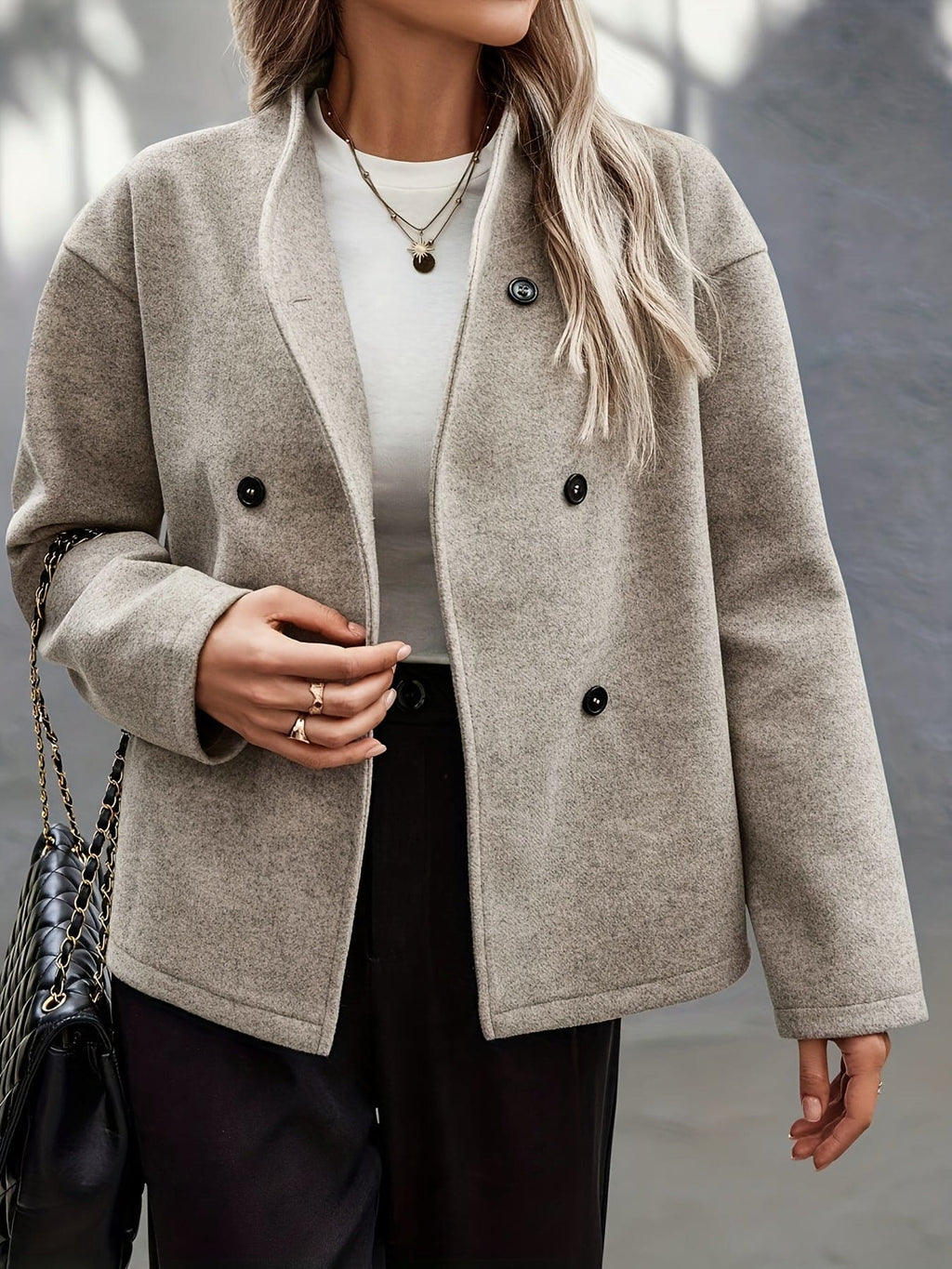 Woman wearing a beige double breasted pea coat with stand collar and oversized silhouette on a city street._4