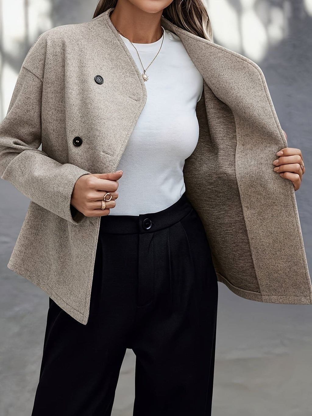 Woman wearing a beige double breasted pea coat with stand collar and oversized silhouette on a city street._5