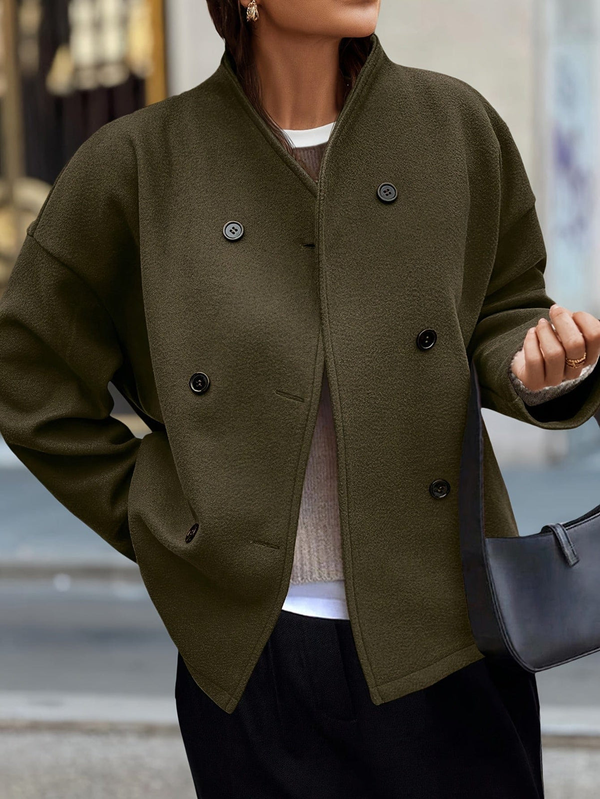 Woman wearing a stand collar pea coat with double breasted button front and relaxed fit over casual layers._0