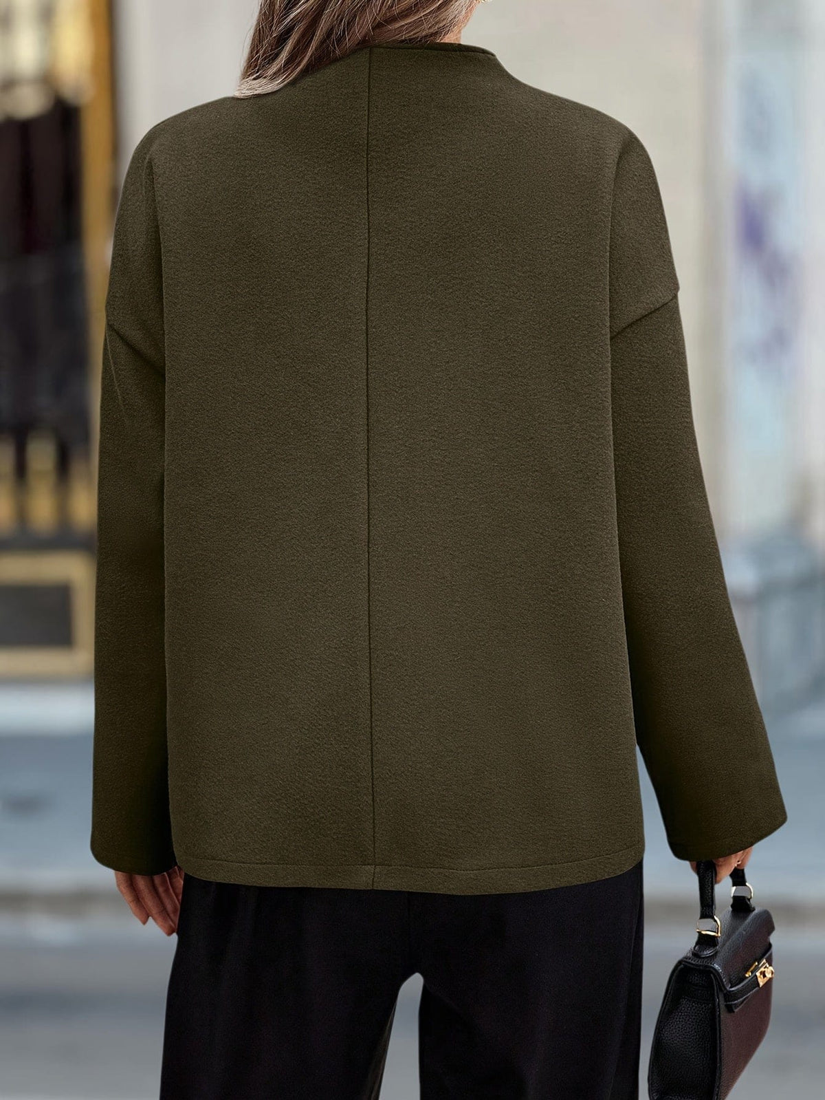 Woman wearing a stand collar pea coat with double breasted button front and relaxed fit over casual layers._2