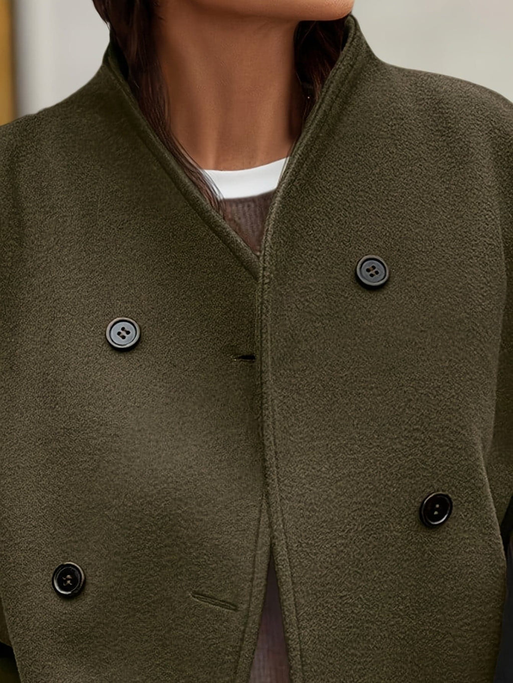 Woman wearing a stand collar pea coat with double breasted button front and relaxed fit over casual layers._3