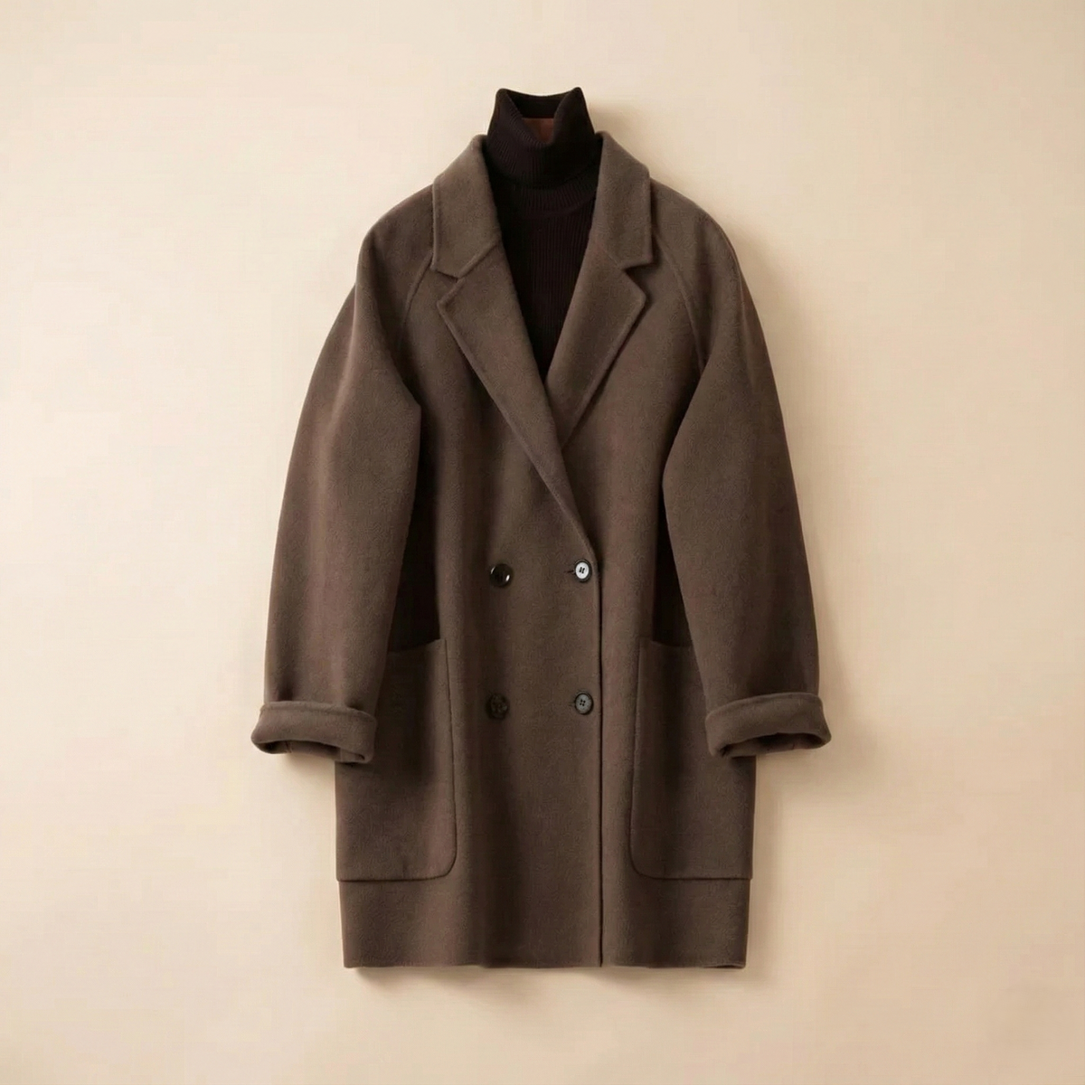 Woman wearing a gray double-breasted coat with rolled cuffs and notched lapels over a black turtleneck_13