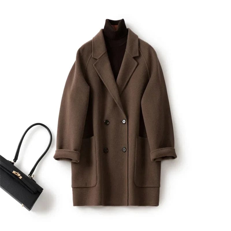 Woman wearing a gray double-breasted coat with rolled cuffs and notched lapels over a black turtleneck_16