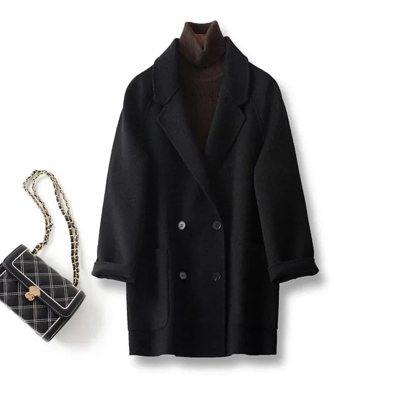 Woman wearing a gray double-breasted coat with rolled cuffs and notched lapels over a black turtleneck_19