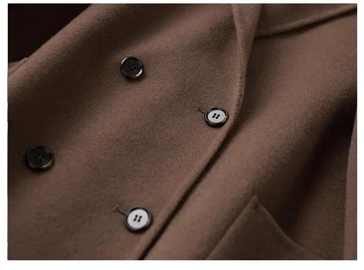 Woman wearing a gray double-breasted coat with rolled cuffs and notched lapels over a black turtleneck_23