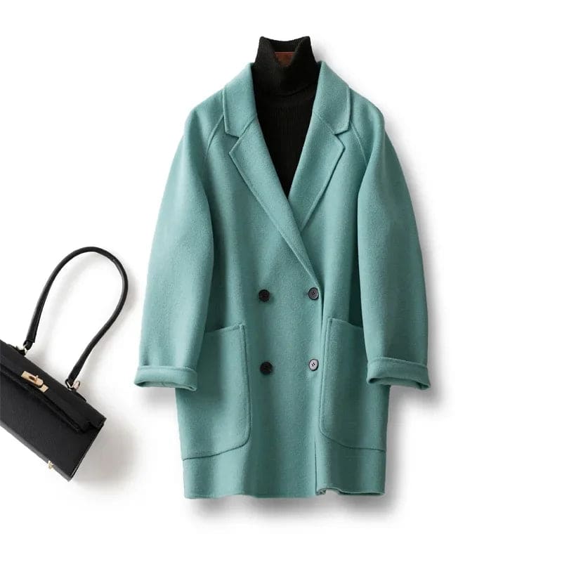 Woman wearing a gray double-breasted coat with rolled cuffs and notched lapels over a black turtleneck_30