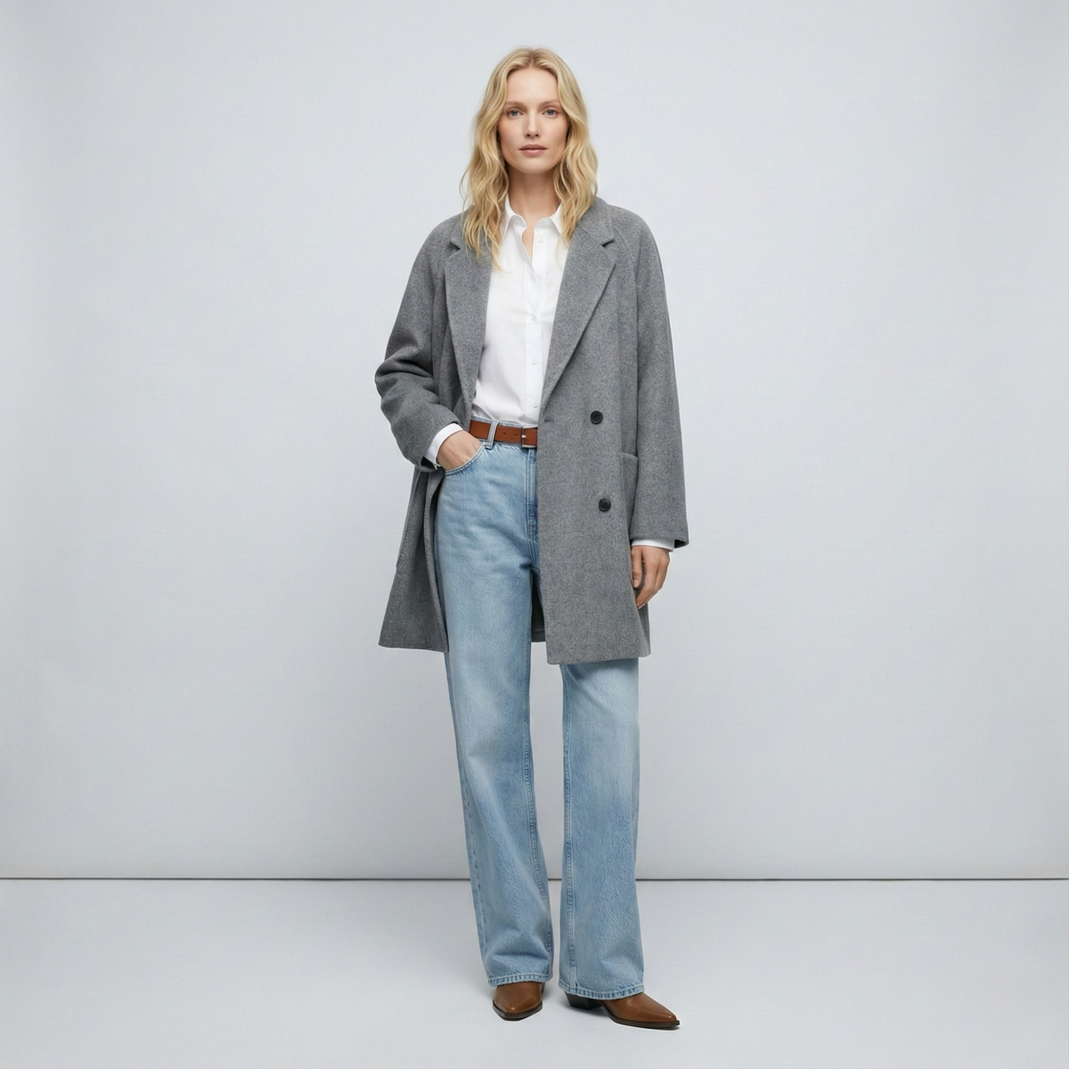 Woman wearing a gray double-breasted coat with rolled cuffs and notched lapels over a black turtleneck_8