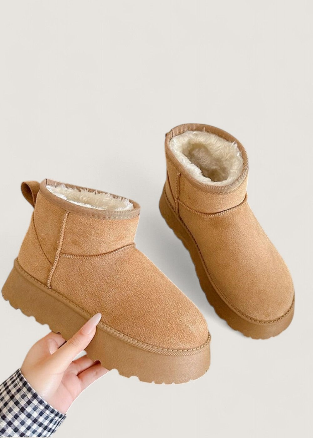Two tan ankle boots shown from above, with their soft faux fur lining visible around the openings.