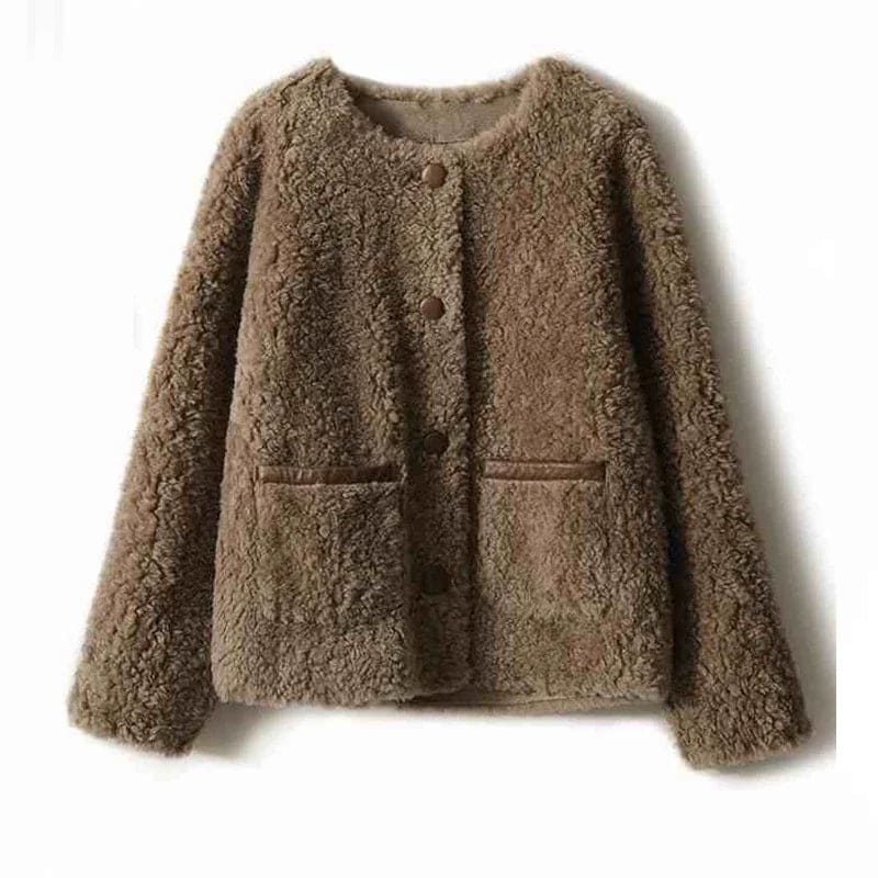 Woman wearing a textured button-front coat with a round neckline over a ribbed turtleneck and matching trousers in a neutral interior setting._15