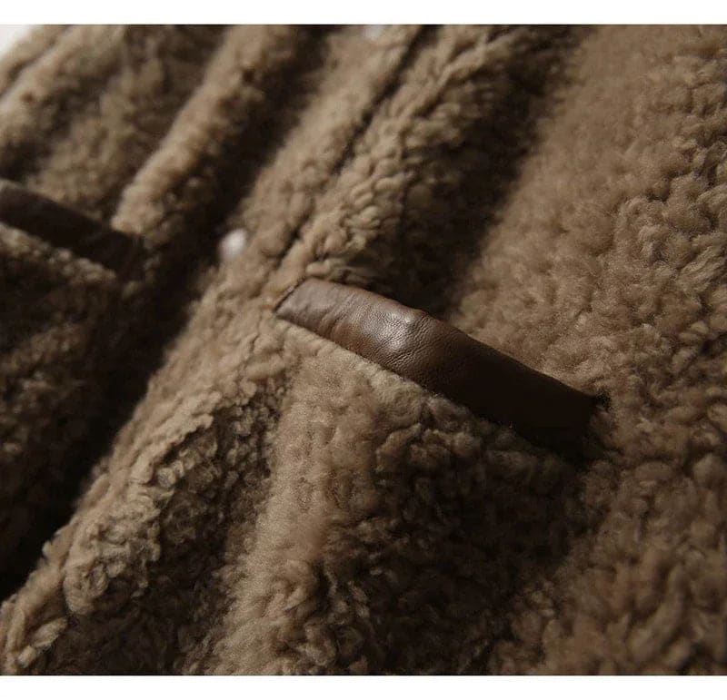 Woman wearing a textured button-front coat with a round neckline over a ribbed turtleneck and matching trousers in a neutral interior setting._16