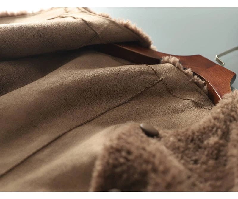 Woman wearing a textured button-front coat with a round neckline over a ribbed turtleneck and matching trousers in a neutral interior setting._18
