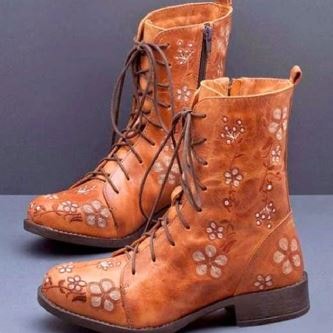 Tan floral embroidered ankle boots with lace-up fronts, rounded toes, side zippers, and low block heels.