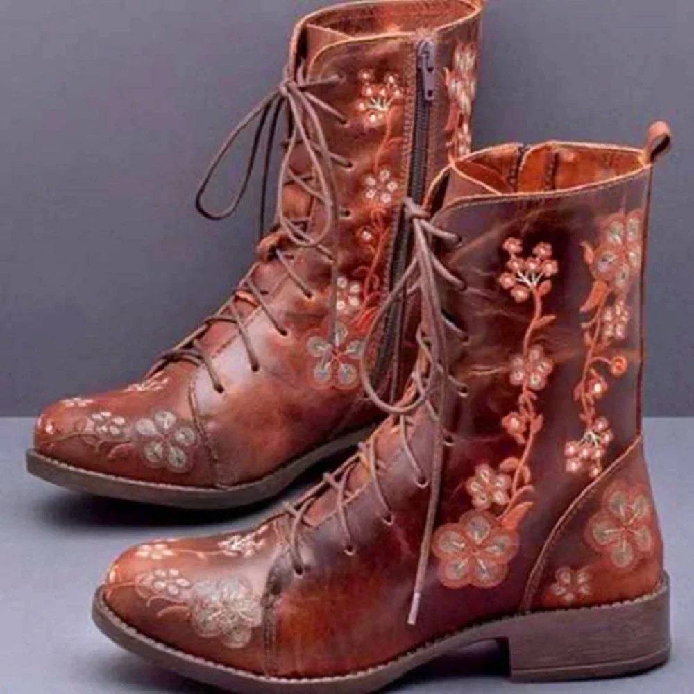 Brown ankle boots with contrasting floral embroidery, long lace-up fronts, side zippers, and sturdy low heels.