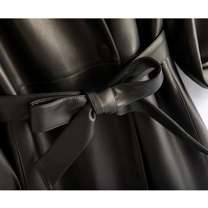 A long-sleeve wrap coat with a V neckline, self-tie waist belt, and softly flared skirt hangs on a wooden hanger._10