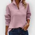Woman wearing a half-zip pullover with all-over ribbed texture and long sleeves, styled with blue jeans._0