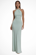 Model wearing a halter neck maxi dress with gathered bodice and open back in a bodycon silhouette._0