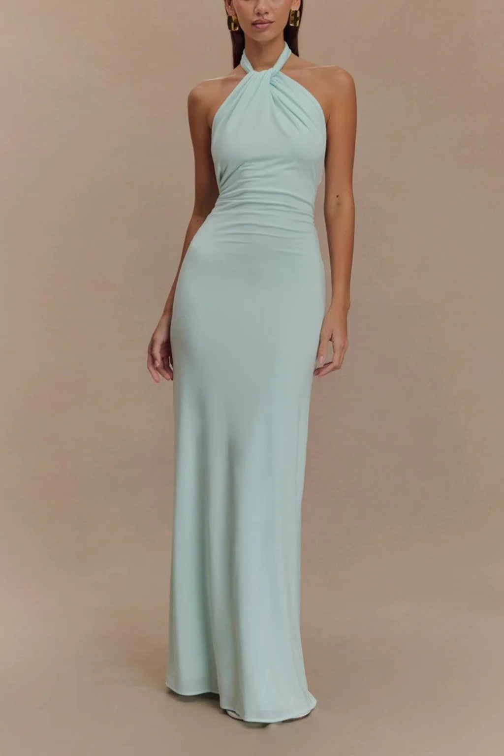 Model wearing a halter neck maxi dress with gathered bodice and open back in a bodycon silhouette._1