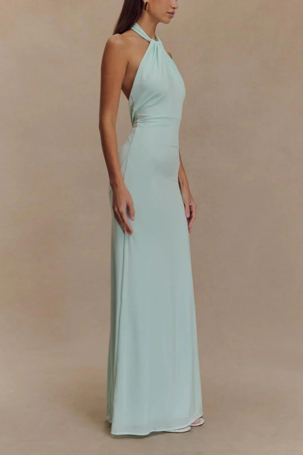 Model wearing a halter neck maxi dress with gathered bodice and open back in a bodycon silhouette._2