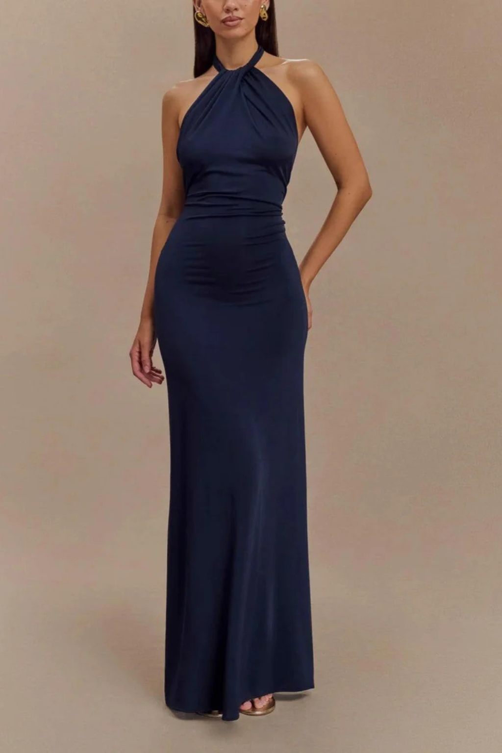 Model wearing a halter neck maxi dress with gathered bodice and open back in a bodycon silhouette._6