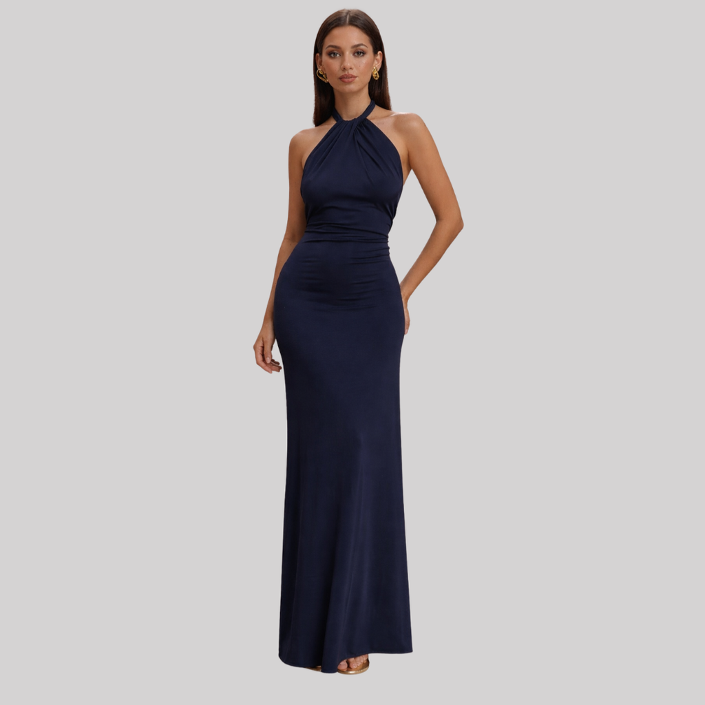 Model wearing a halter neck maxi dress with bodycon fit, open back design, and floor-length hem in a soft pastel shade._3