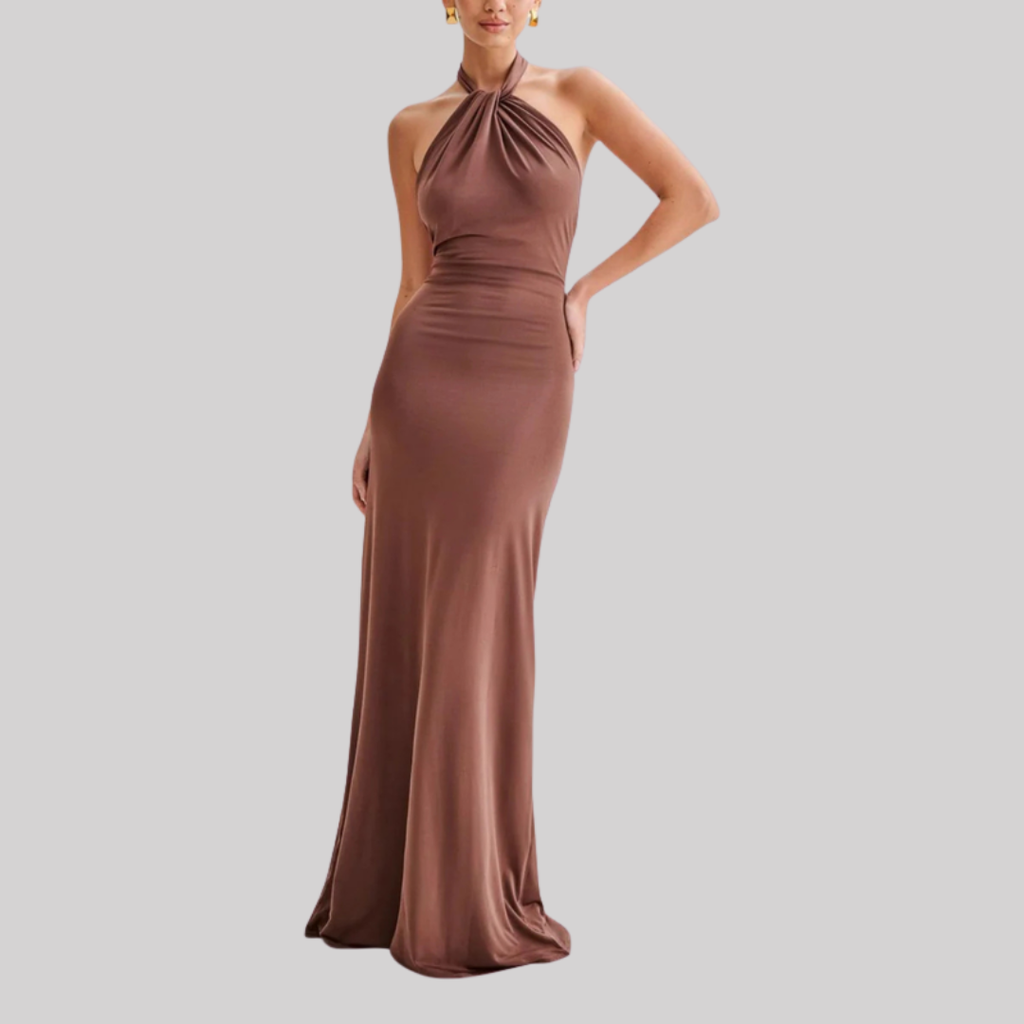 Model wearing a halter neck maxi dress with bodycon fit, open back design, and floor-length hem in a soft pastel shade._6