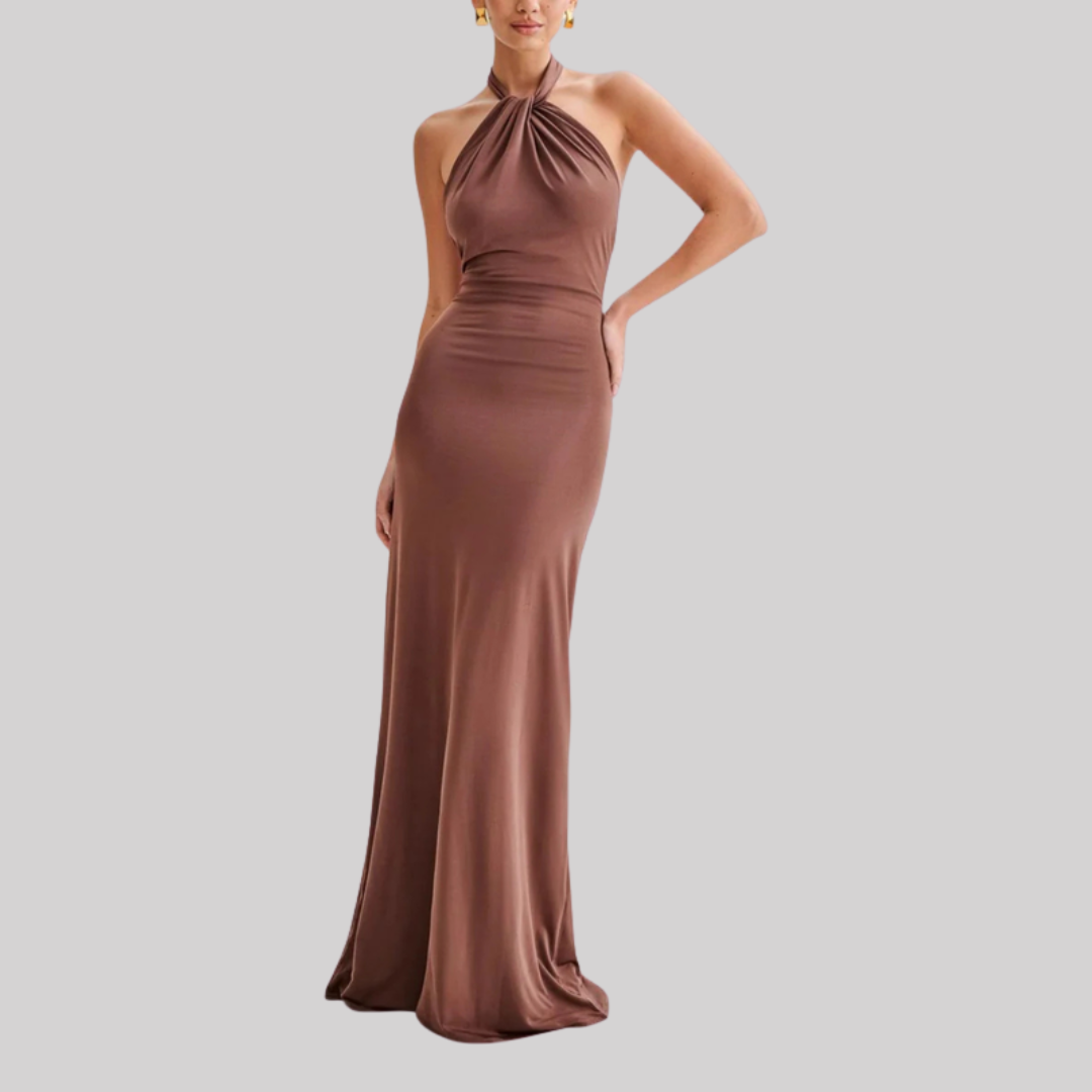 Model wearing a halter neck maxi dress with bodycon fit, open back design, and floor-length hem in a soft pastel shade._6