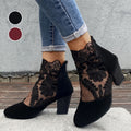 Woman wearing heeled ankle boots featuring sheer floral lace panels, solid toe and heel, and studded block heel detail with cuffed jeans._0