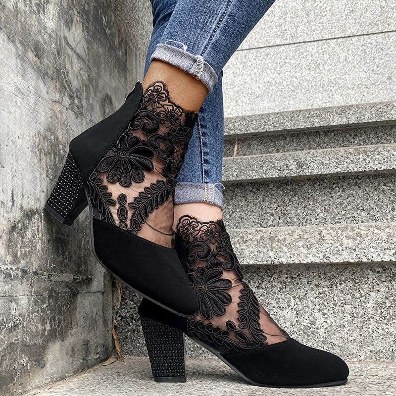 Woman wearing heeled ankle boots featuring sheer floral lace panels, solid toe and heel, and studded block heel detail with cuffed jeans._3