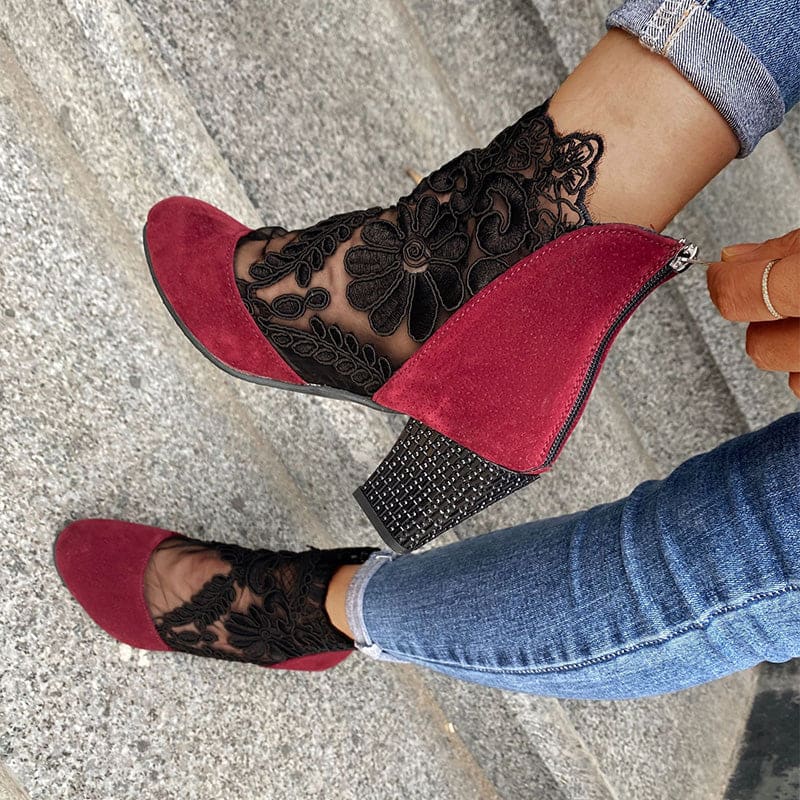 Woman wearing heeled ankle boots featuring sheer floral lace panels, solid toe and heel, and studded block heel detail with cuffed jeans._5