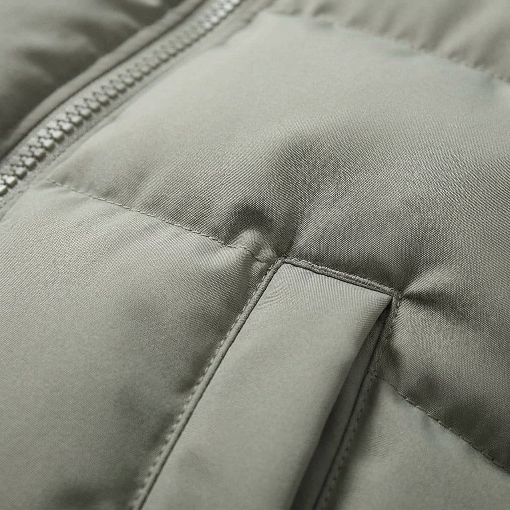 Woman wearing a cream hooded puffer jacket with quilted design outdoors in a park setting._7