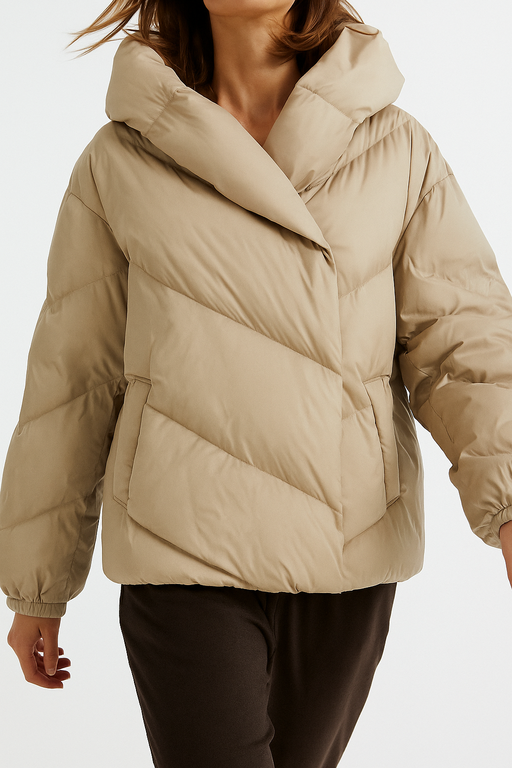 Woman wearing a hooded quilted puffer jacket in a cropped relaxed fit, styled with a light sweater and trousers._11