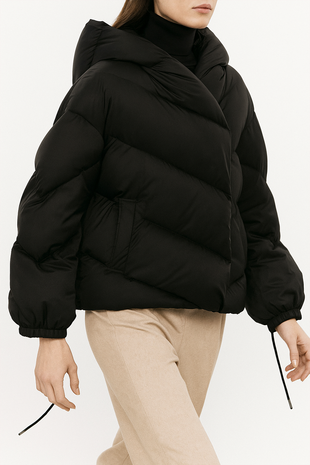 Woman wearing a hooded quilted puffer jacket in a cropped relaxed fit, styled with a light sweater and trousers._12