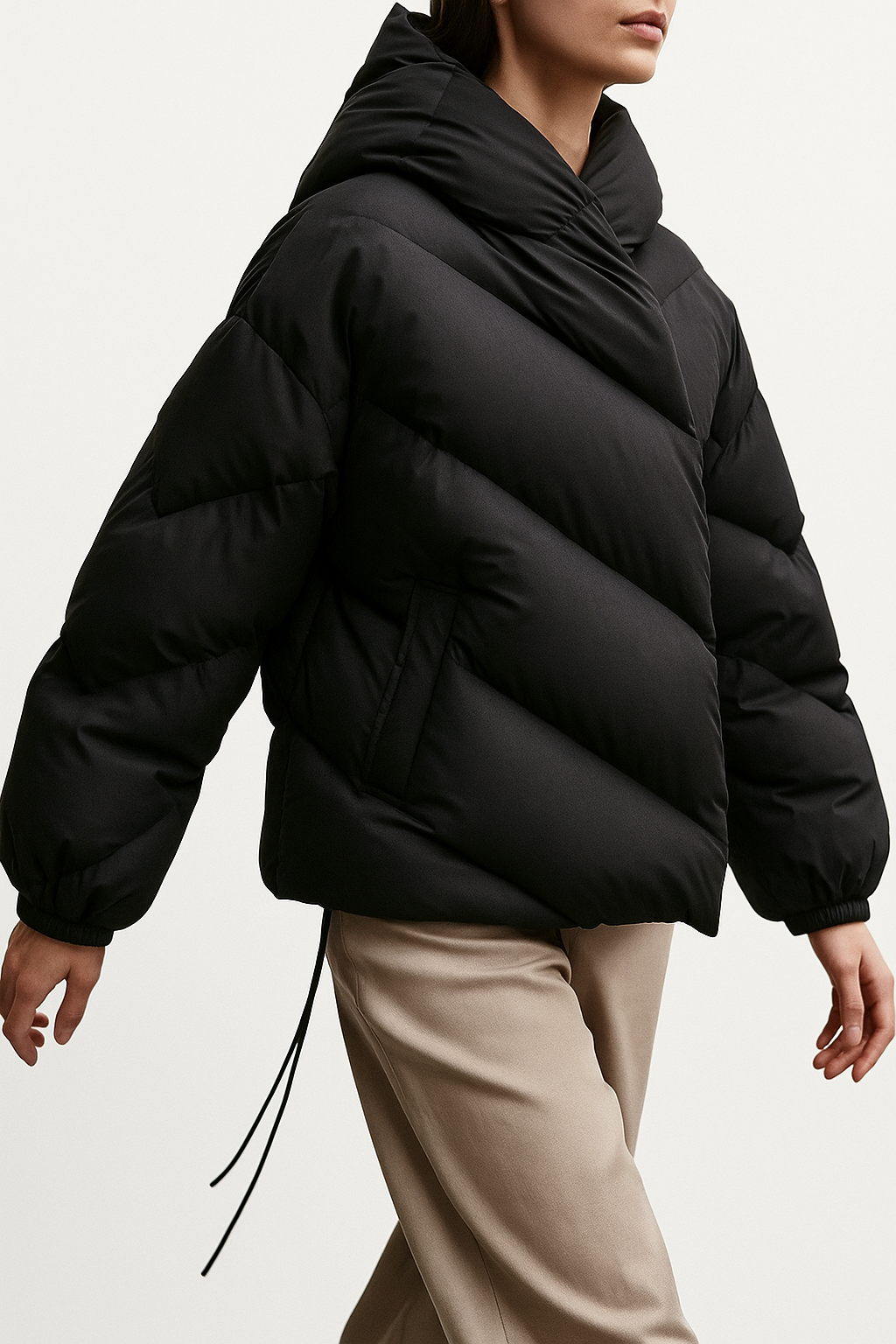 Woman wearing a hooded quilted puffer jacket in a cropped relaxed fit, styled with a light sweater and trousers._13