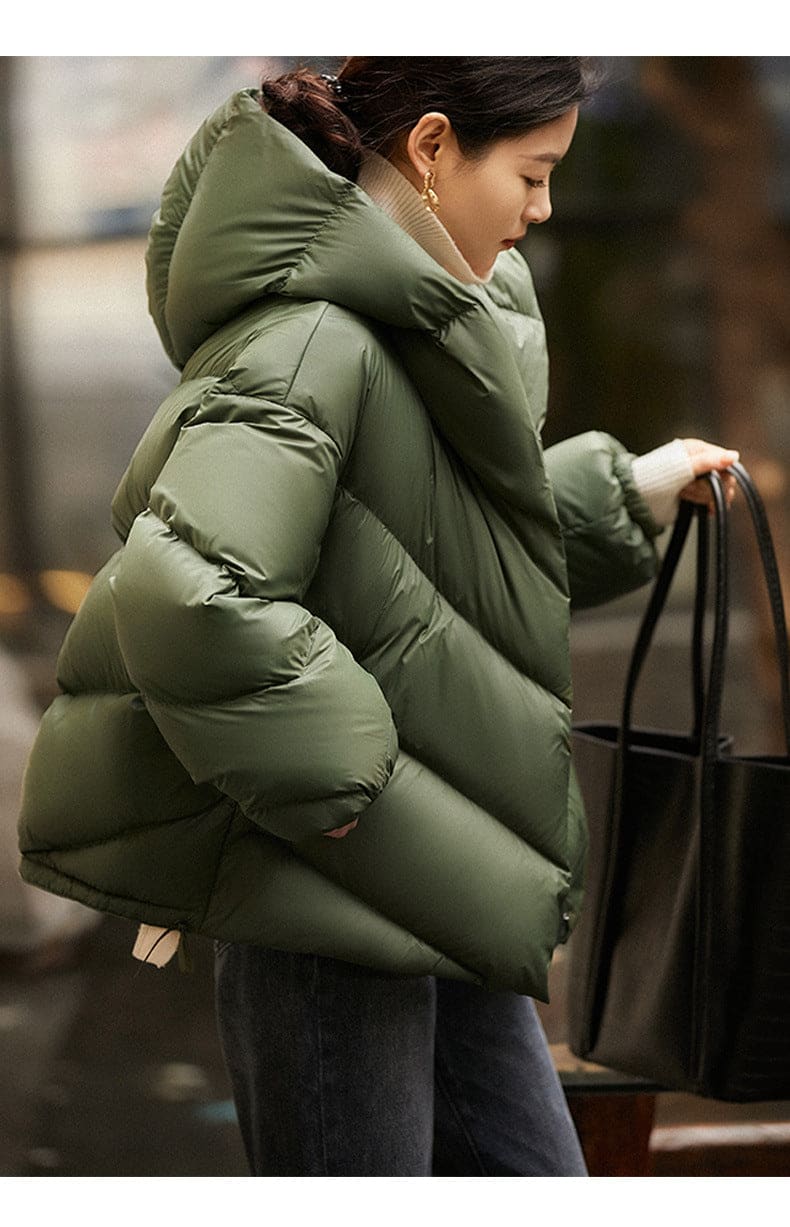 Woman wearing a hooded quilted puffer jacket in a cropped relaxed fit, styled with a light sweater and trousers._17