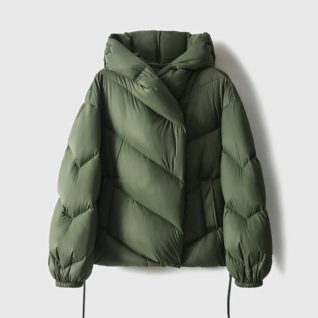 Woman wearing a hooded quilted puffer jacket in a cropped relaxed fit, styled with a light sweater and trousers._18