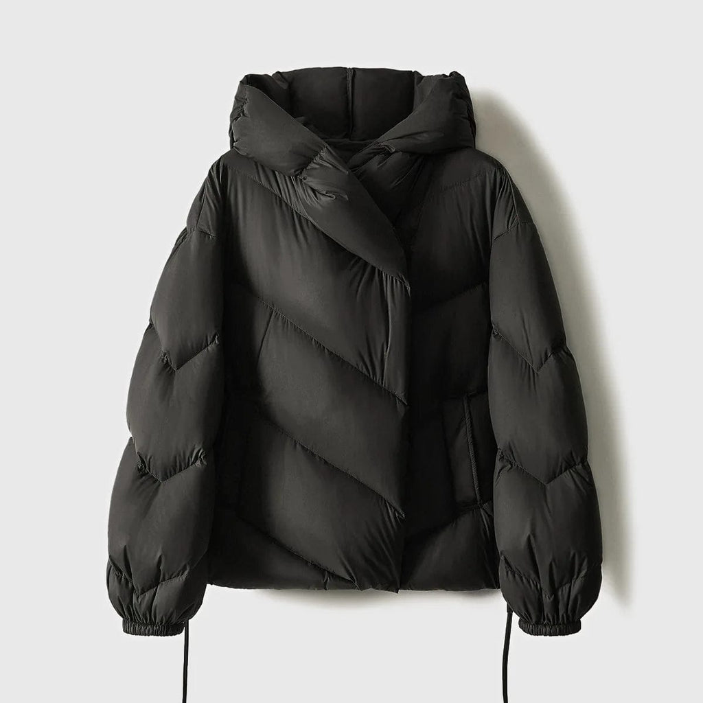 Woman wearing a hooded quilted puffer jacket in a cropped relaxed fit, styled with a light sweater and trousers._20