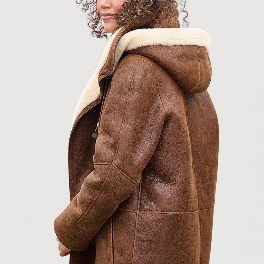 Woman wearing a brown hooded toggle coat with a sherpa collar and warm lining._1