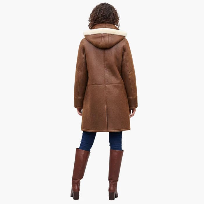 Woman wearing a brown hooded toggle coat with a sherpa collar and warm lining._4
