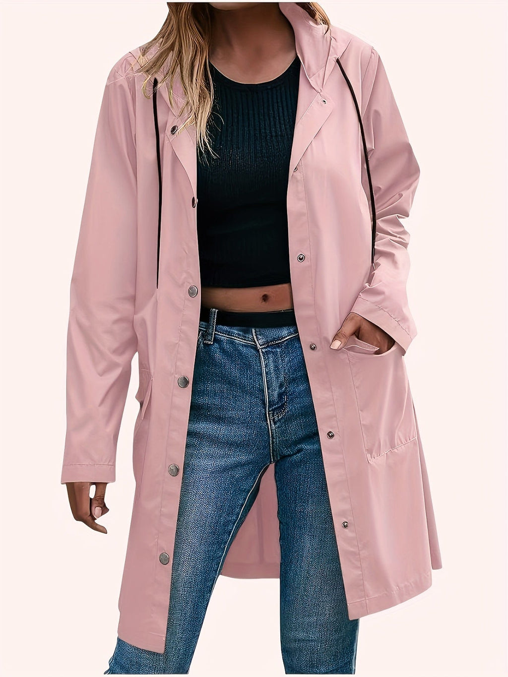 Model wearing a longline hooded trench coat with button-front closure over a black top and jeans._0