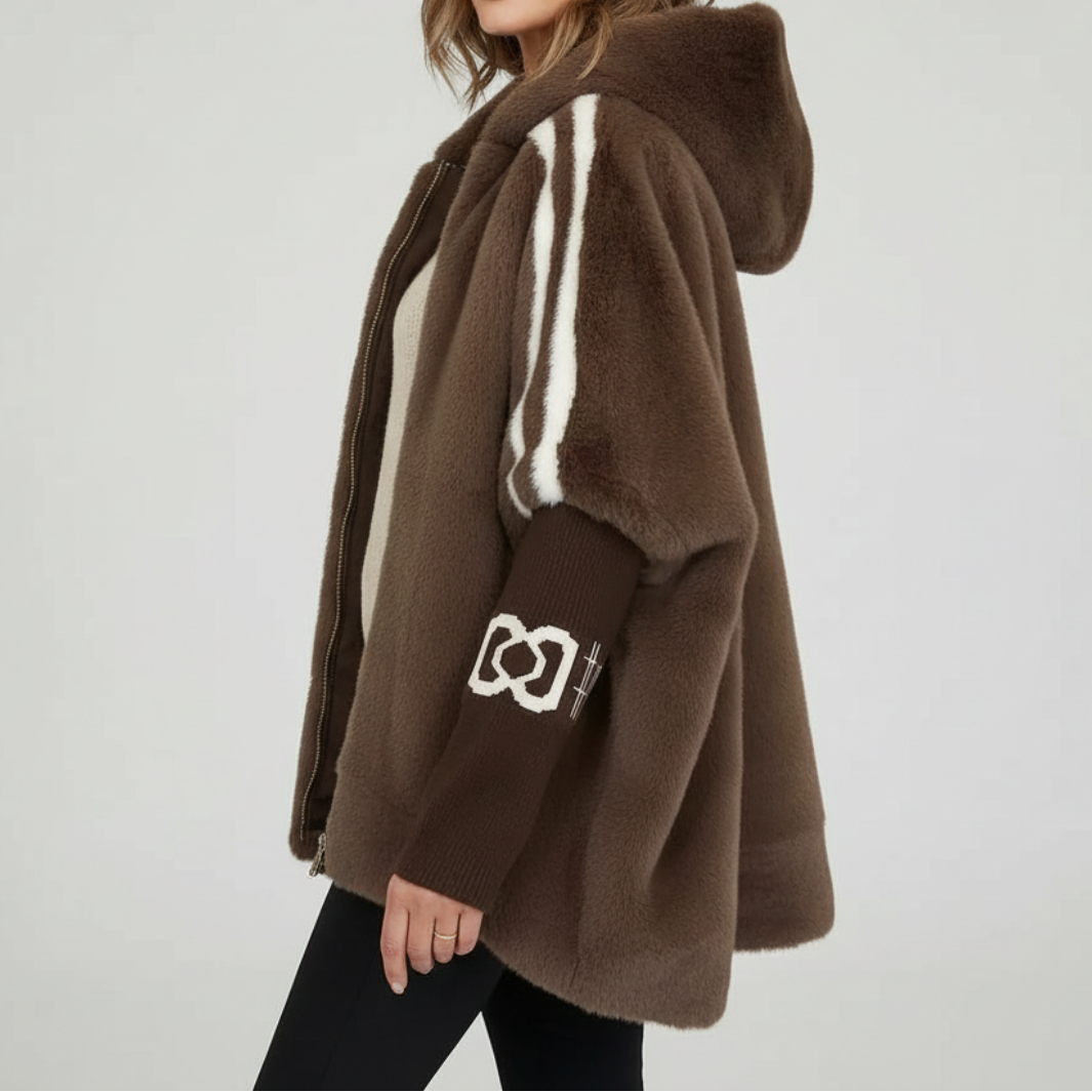 Woman wearing an oversized hooded zip-up jacket with white sporty stripes on the sleeves and ribbed cuffs, styled over a neutral top and black pants._1