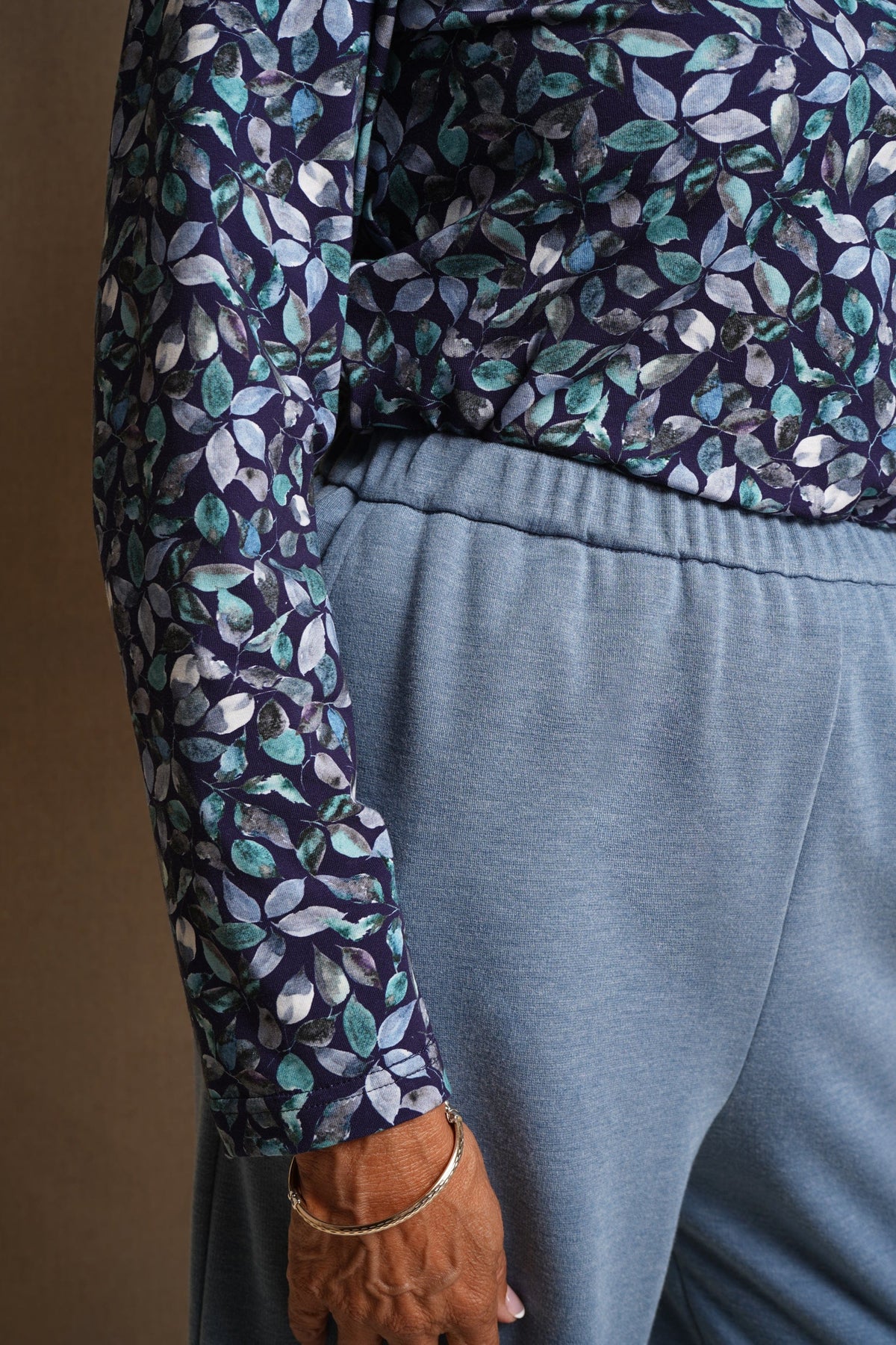 Woman wearing light blue wide leg trousers with an elasticated waistband and side pockets, styled with a floral blouse and black heels._2