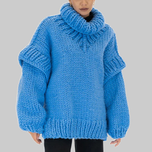 Woman wearing an oversized bright blue chunky knit turtleneck sweater with long sleeves and black trousers._0