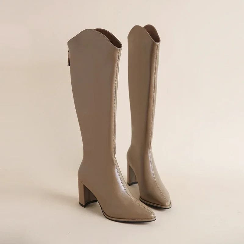 Pair of black knee high boots with pointed toe and block heel displayed against a neutral background._7