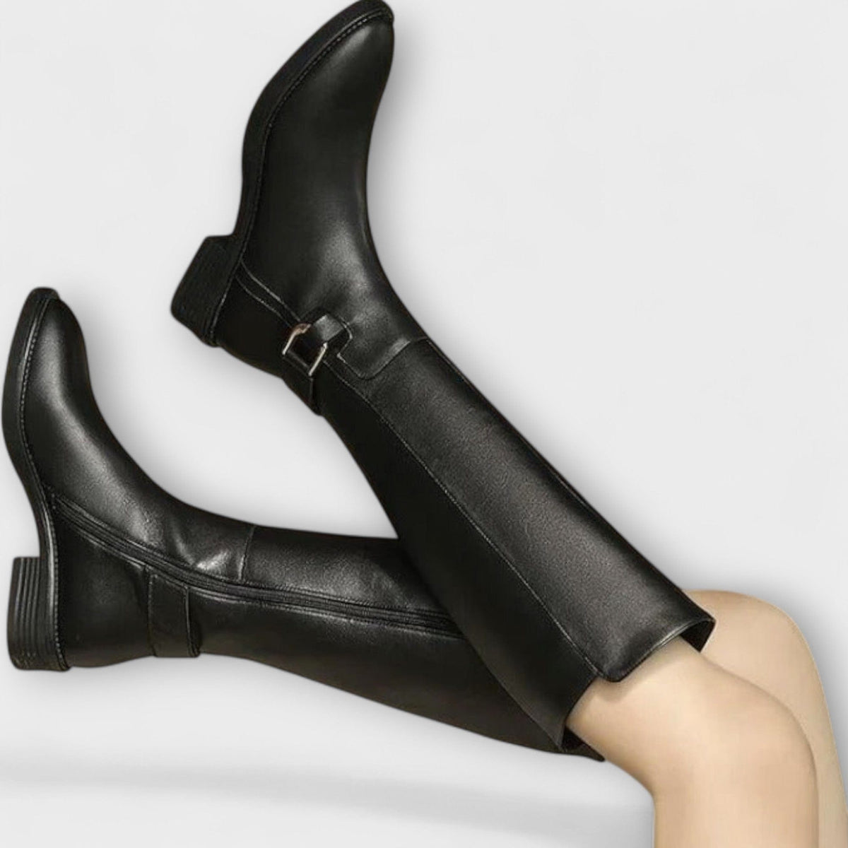 Model wearing knee high boots with a block heel and buckle detail, styled with a pleated skirt._2