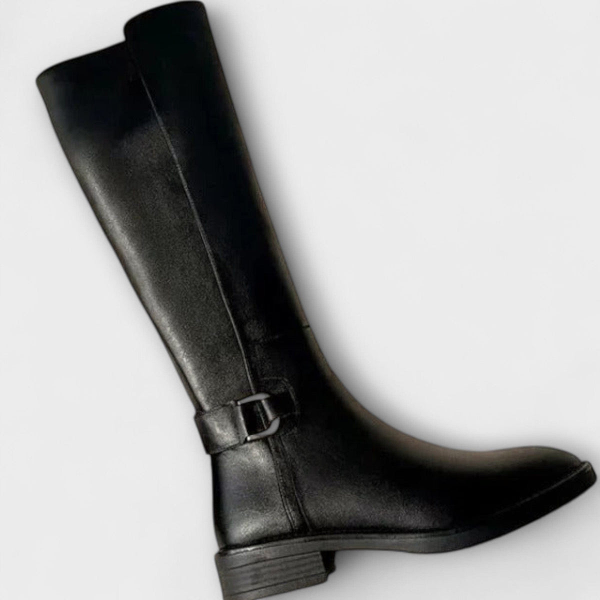 Model wearing knee high boots with a block heel and buckle detail, styled with a pleated skirt._4